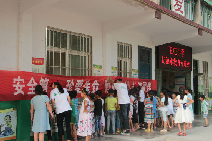 小朋友在防溺水宣传条幅上签字(摄å½?胡鸿博).JPG
